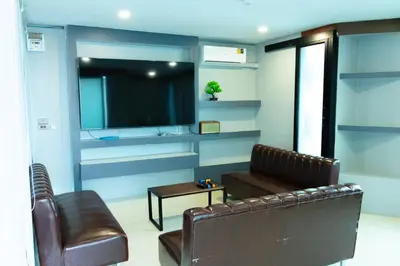 a living room with a couch and a television at Cabanaz Pool Villa in Ban Zong Katiam