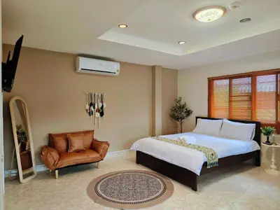 a bedroom with a bed and a chair at Relax Inn DMK in Lak Si