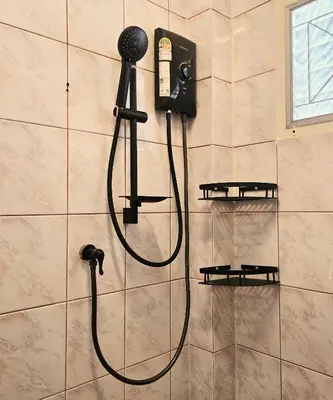 a shower with a blow dryer on a wall at Relax Inn DMK in Lak Si