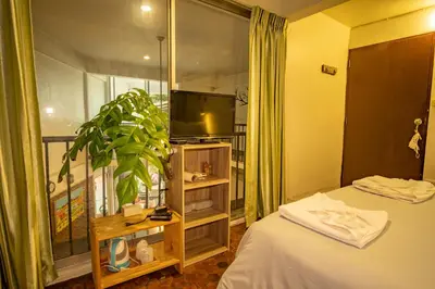 a room with a bed and a tv and a window at Home16 Sukhumvit16 in Bangkok