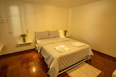 a small bedroom with a bed with a white blanket at Home16 Sukhumvit16 in Bangkok