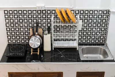 a kitchen counter top with a sink and a clock at Home 18 - Cozy Hideout in Bangkok in Bangkok