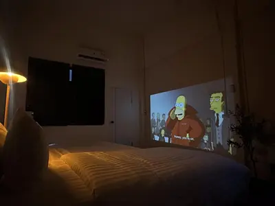 a bedroom with a bed with a large screen at Home 18 - Cozy Hideout in Bangkok in Bangkok