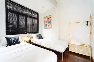 a bedroom with two beds and a window at Home 18 - Cozy Hideout in Bangkok in Bangkok