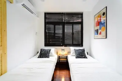 two white beds in a room with a window at Home 18 - Cozy Hideout in Bangkok in Bangkok