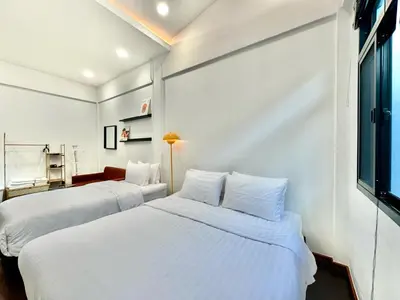 two beds in a room with white walls at Home 18 - Cozy Hideout in Bangkok in Bangkok