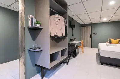 a room with a bed and a dressing room at Floton Bangkok Hotel in Bangkok