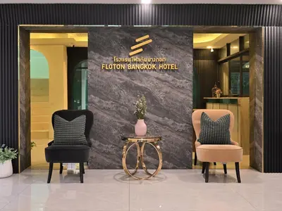 two chairs and a table in front of a lobby at Floton Bangkok Hotel in Bangkok