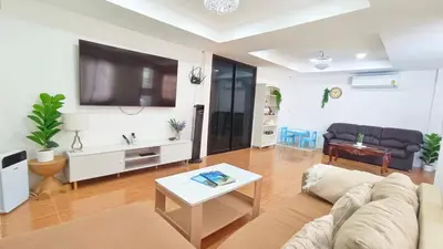 a living room with a couch and a tv at Retreat House 81 - BTS Onnut in Bangkok