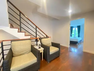 a living room with two chairs and a staircase at 3 Bedroom Spacious Home in Downtown Bangkok Near MRT BTS Asok Station in Bangkok