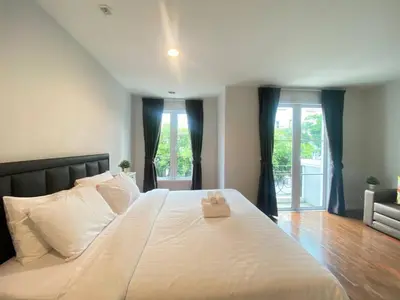 a large white bed in a room with windows at 3 Bedroom Spacious Home in Downtown Bangkok Near MRT BTS Asok Station in Bangkok