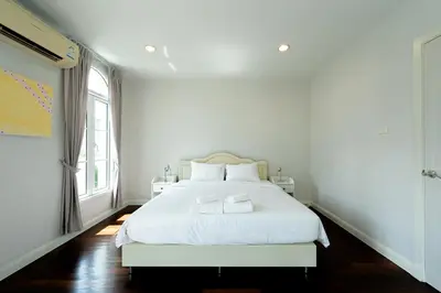 a white bedroom with a white bed and a window at 3 Bedroom Spacious Home in Downtown Bangkok Near MRT BTS Asok Station in Bangkok