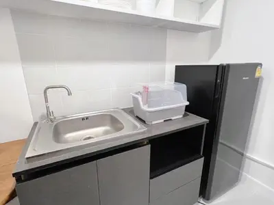 a kitchen with a sink and a refrigerator at Impact - Donmueng Popular C4 in Ban Song Hong