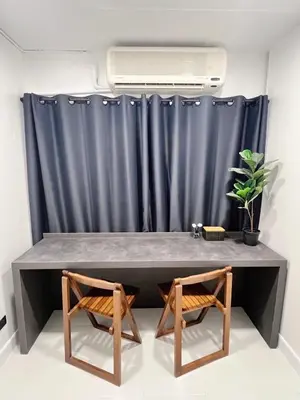 a table and two chairs in front of a curtain at Impact - Donmueng Popular C4 in Ban Song Hong