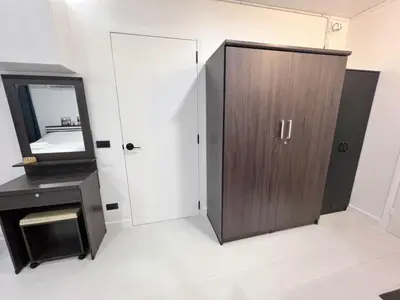 a bathroom with a wooden cabinet and a mirror at Impact - Donmueng Popular C4 in Ban Song Hong