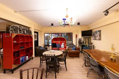 a living room with a table and chairs at Orange Lodge in Bangkok