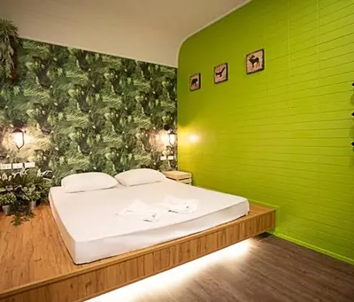a bedroom with a green wall with a bed at NY Resort Nonthaburi in Nonthaburi