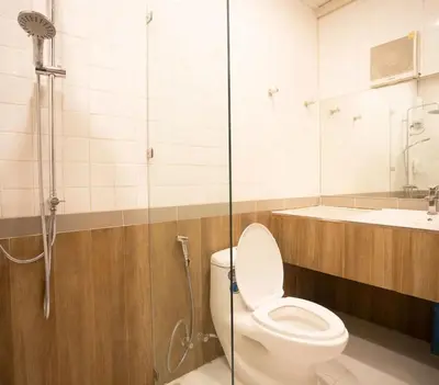 a bathroom with a toilet and a shower at NY Resort Nonthaburi in Nonthaburi