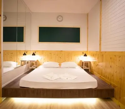 a bedroom with a large white bed with two lamps at NY Resort Nonthaburi in Nonthaburi