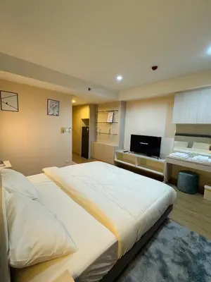 a large bedroom with a large bed and a desk at Inspire place rama9 Modern Condo near Rajamangala Stadium Pool and Gym in Bangkok