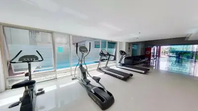 a gym with three treadmills and a swimming pool at Inspire place rama9 Modern Condo near Rajamangala Stadium Pool and Gym in Bangkok