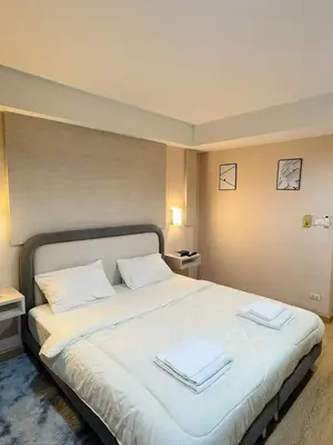 a bedroom with a large white bed with towels on it at Inspire place rama9 Modern Condo near Rajamangala Stadium Pool and Gym in Bangkok