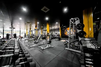 a gym with rows of equipment and people in it at River View 8 in Yan Nawa