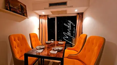 a dining room with a table and orange chairs at River View 8 in Yan Nawa