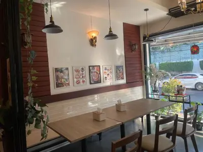 a dining room with a wooden table and chairs at M3 Bangkok Bake & Bed in Bangkok