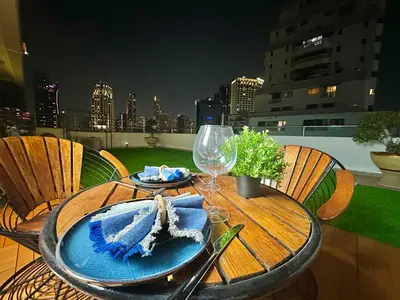 a table with a plate of food on a balcony at Luxury 3 bedrooms in the heart of the city in Bangkok