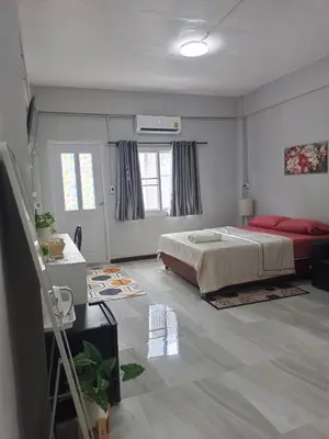 a bedroom with a bed and a desk in it at The little home in Bangkok