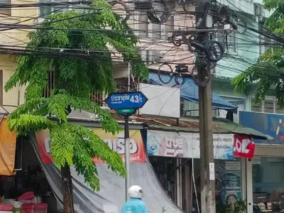 a blue street sign in front of a building at The little home in Bangkok