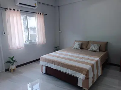 a bedroom with a bed and a window at The little home in Bangkok