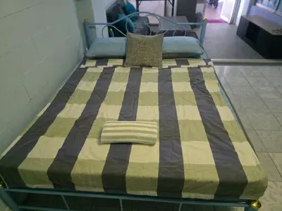 a bed with a checkered blanket on it at Beautiful Studio 107 Apartment with nice living room with WiFi in Bangkok