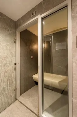 a bathroom with a sliding glass door with a toilet at 1BR Apt - Pool, Gym, Rooftop, BTS, Coworking Space - 10 min Nana Plaza - Central - New Building - 24 7 Security in Bangkok
