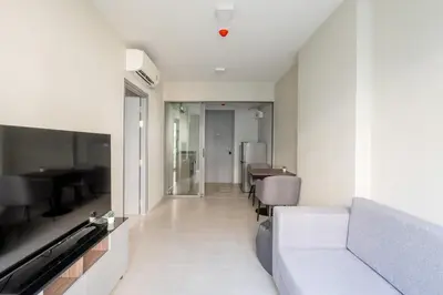 a living room with a couch and a television at 1BR Apt - Pool, Gym, Rooftop, BTS, Coworking Space - 10 min Nana Plaza - Central - New Building - 24 7 Security in Bangkok