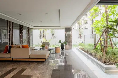 a living room with a couch and a large window at 1BR Apt - Pool, Gym, Rooftop, BTS, Coworking Space - 10 min Nana Plaza - Central - New Building - 24 7 Security in Bangkok