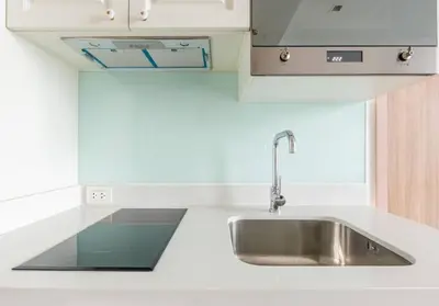 a stainless steel sink in a white kitchen at Phrom Phong Top 1BD pool,gym,park and mall BTS in Khlong Toei