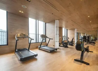 a gym with several treadmills and exercise bikes in it at Phrom Phong Top 1BD pool,gym,park and mall BTS in Khlong Toei