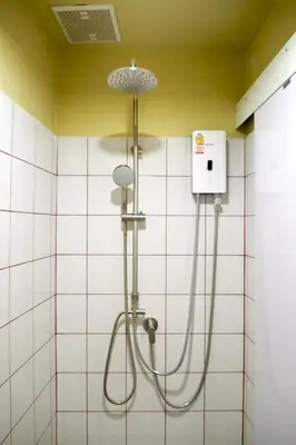 a shower in a bathroom with white tiles at BaanBaan - Cozy home 5pax, 5min BTS, Boat, old town explore in Bangkok