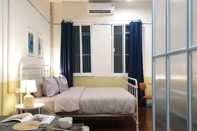 a bedroom with a bed and a desk with a table at BaanBaan - Cozy home 5pax, 5min BTS, Boat, old town explore in Bangkok