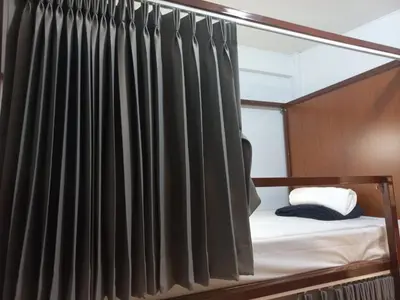 a bedroom with a canopy bed with black curtains at Delight Hostel at Khao San in Bangkok