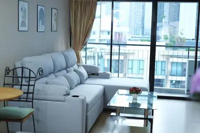 a living room with a white couch and a large window at convenient&peaceful place in Soi nai leot in Bangkok