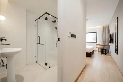 a bathroom with a shower and a sink at Asoka Hotel at Asoke Makkasan in Bangkok