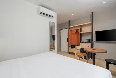 a bedroom with a bed and a desk and a table at Asoka Hotel at Asoke Makkasan in Bangkok