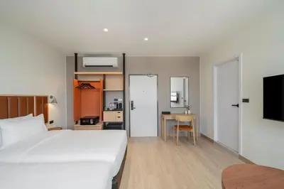a bedroom with a bed and a table with a kitchen at Asoka Hotel at Asoke Makkasan in Bangkok