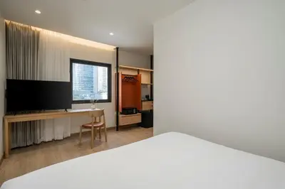 a hotel room with a bed and a television at Asoka Hotel at Asoke Makkasan in Bangkok