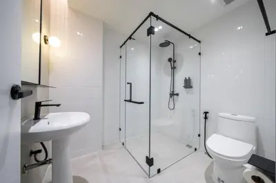 a bathroom with a shower and a toilet and a sink at Asoka Hotel at Asoke Makkasan in Bangkok