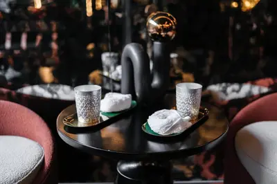 a table with two plates of whipped cream and two cups at Hotel 433 - Asoke Sukhumvit in Bangkok