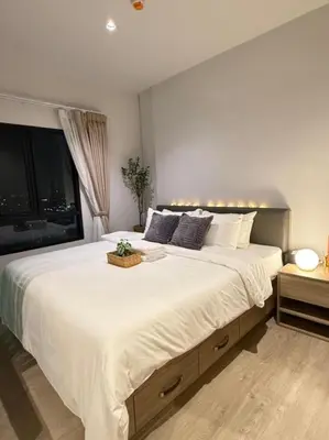 a bedroom with a large white bed with a window at คอนโดติด bts ตลาดพลู 0 เมตร ใกล้ Iconsiam ว่างรายเดือน in Thonhuri